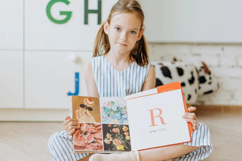 Young girl reading illustrated book independently after completing phonics instruction