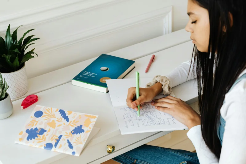Homeschool student writing essay and homework at organized desk