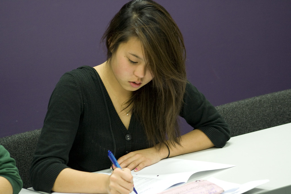 Student working on grammar exercises at desk