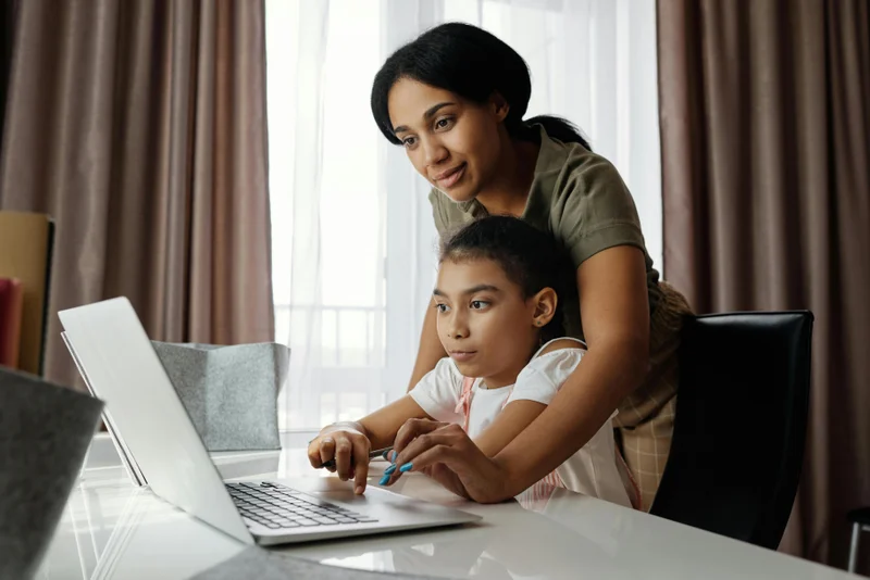 Parent and child working together on homeschool materials after withdrawing from public school