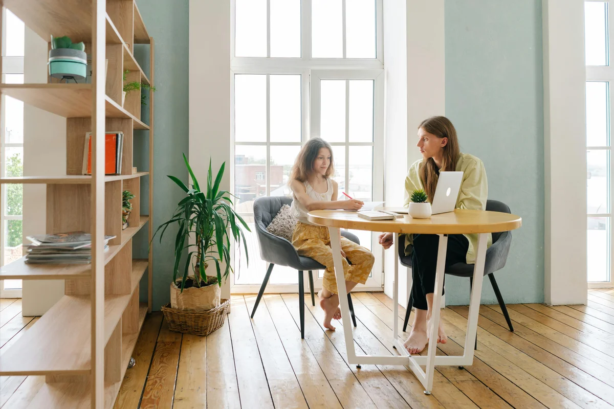 Mother and daughter studying together at table - Florida homeschool family learning at home