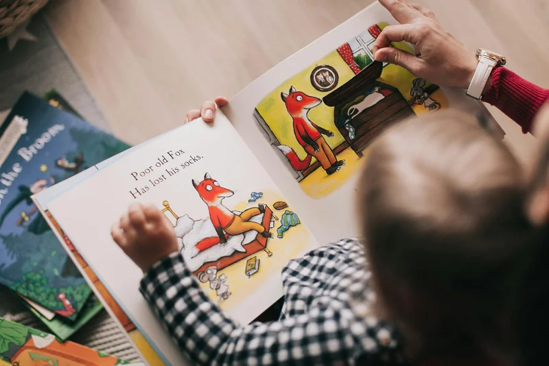 A parent and child reading a storybook together, similar to the Life of Fred experience