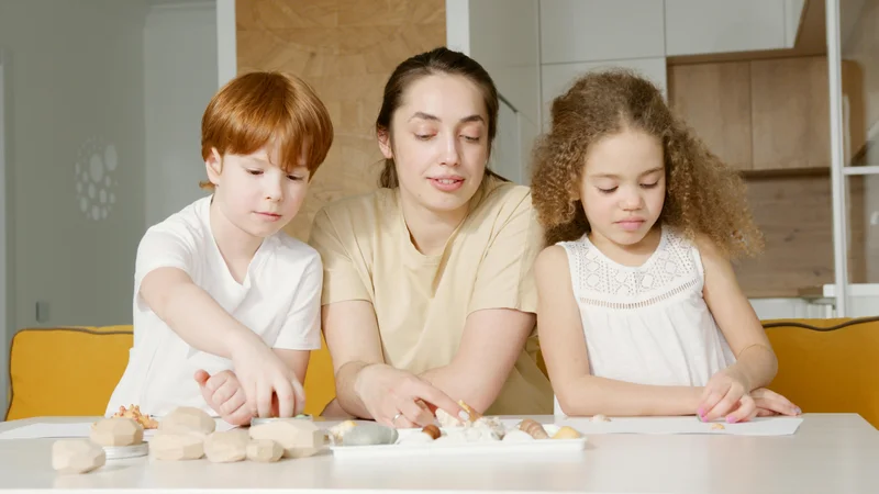 Mother helping multiple children with different ages during homeschool lesson
