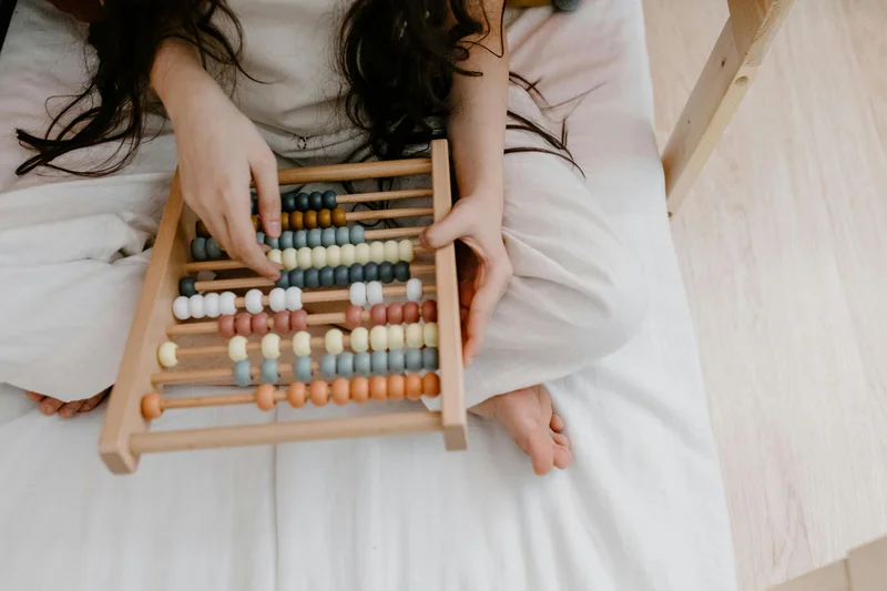 A child using a colorful abacus to learn math concepts with RightStart Mathematics