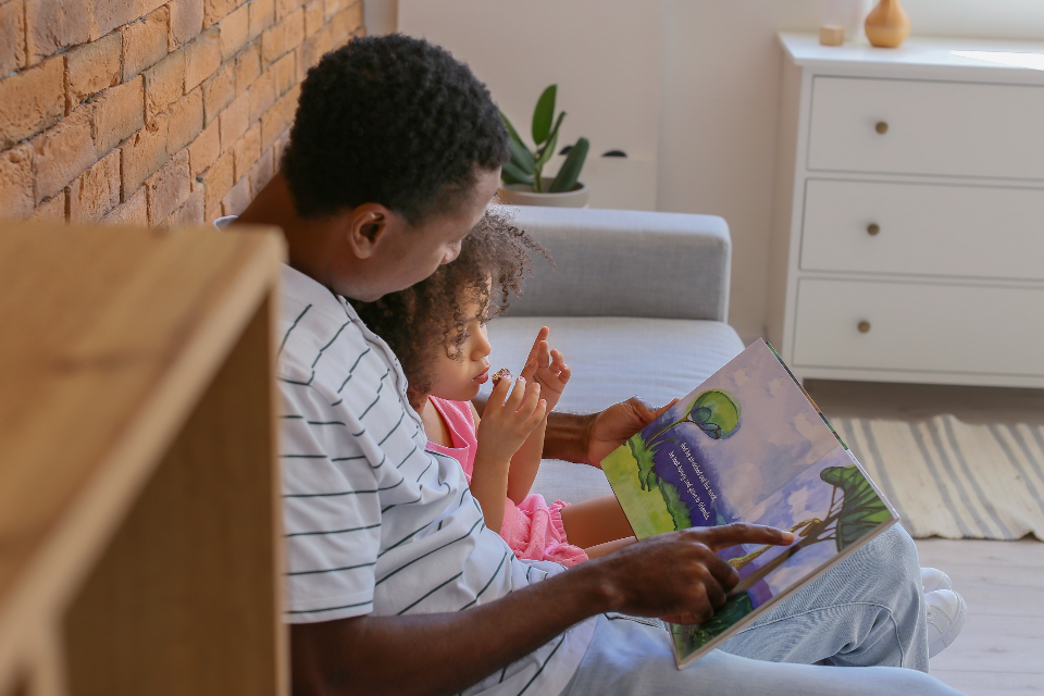 Father and child reading together on couch, representing Sonlight's read-aloud emphasis