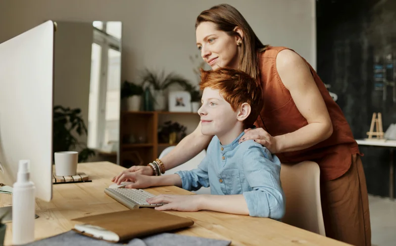 Mother and child smiling while learning on computer - Texas homeschool family
