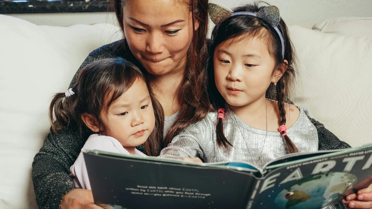 Mother and children reading a book together while homeschooling in Washington