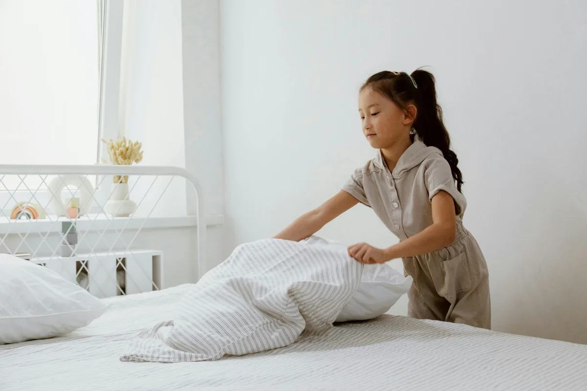 Child making bed - Charlotte Mason habit training in action