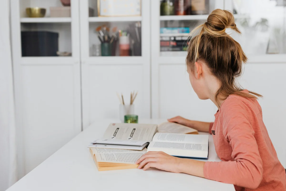 Homeschool student studying at desk with books